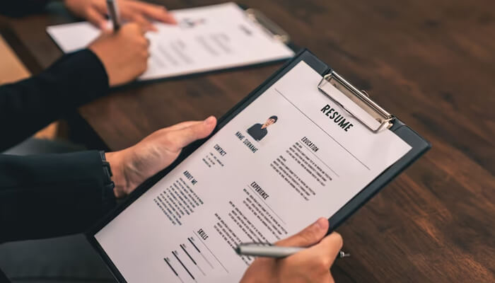 Here are some tips for writing an accounting resume Accounting resume being reviewed on a clipboard during a professional hiring or interview process