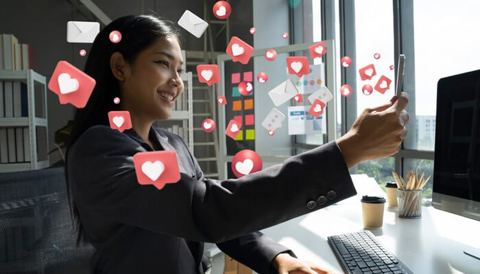 Influencer marketing Influencer creating social media content on a smartphone with floating like, heart, and engagement icons representing influencer marketing and audience growth.