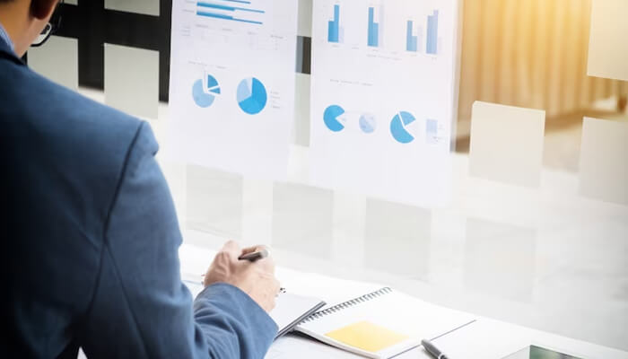 Passion Business professional analyzing financial charts and graphs on a glass board