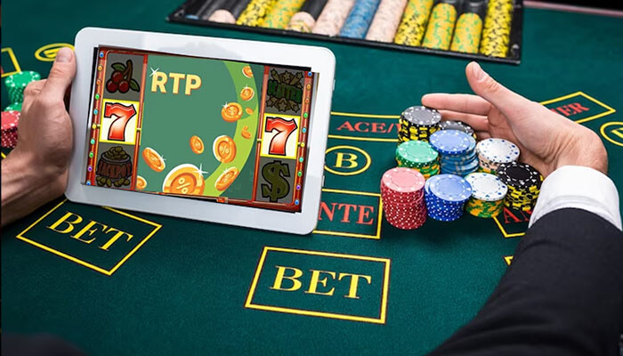 What does the rtp rate mean A person playing online slots on a tablet, with rtp (return to player) displayed on the screen, while holding poker chips on a casino table.