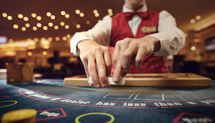 Gambling A casino dealer dealing cards at a blackjack table, showcasing the excitement of gambling in casinos. Focus keywords: "gambling" and "casinos. "