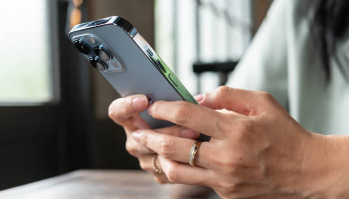 Guide to creating stunning composite images on your iphone Close-up shot of hands holding an iphone, displaying how to combine multiple photos on iphone using the editing tools.