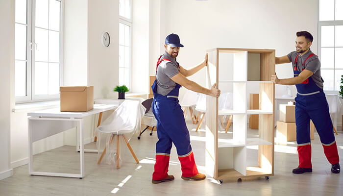 Hire professional cleaners Two movers helping with an office move, carrying furniture to the new office space.