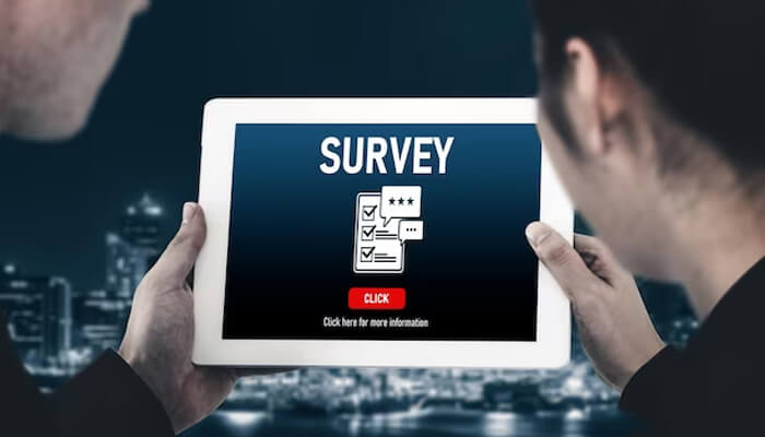 Surveys People holding a tablet displaying online surveys with checklist icons and rating stars against a city skyline background.