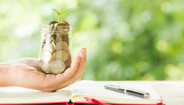 Restaurant business Restaurant business financial growth concept showing hand holding jar of coins with plant sprout symbolizing profit and investment planning.