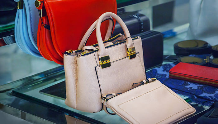 The craft of creating high quality bags Bag making machine finished products displaying premium handbags and wallets on a retail shelf, representing commercial bag production and design.