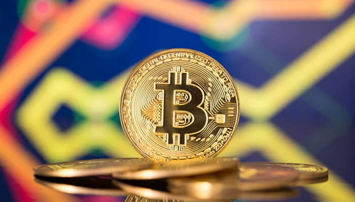 Big eyes Golden bitcoin coin standing upright with colorful market chart background related to big eyes crypto discussions.