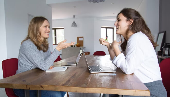 Women-discussed-tycoonstory | tycoonstory media Two professionals, likely engaged in a business discussion, sharing ideas and collaborating, possibly reflecting the values of julie roehm's leadership style.