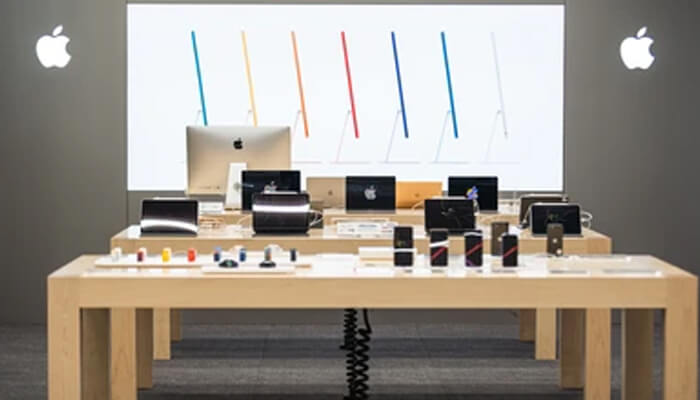 Apple Interior of an apple store showcasing various apple products such as imacs, macbooks, ipads, and accessories arranged on wooden tables.