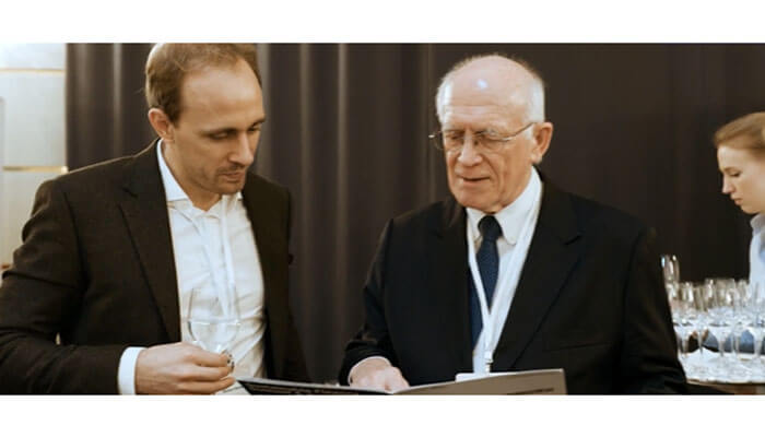 Budget friendly conference hunting Attendees networking and discussing at a conference in canada, with one person showing materials to another during a break