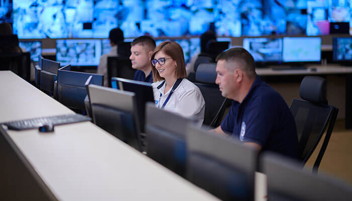 Regularly monitor and maintain your storage system Security operations staff working at computer monitors in a high-tech control room, overseeing and managing digital storage systems and data infrastructure.