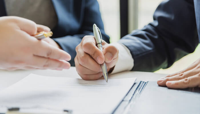 What is a forbrukslånutensikkerhet Forbrukslånutensikkerhet agreement process with financial advisors reviewing and signing unsecured loan documents.
