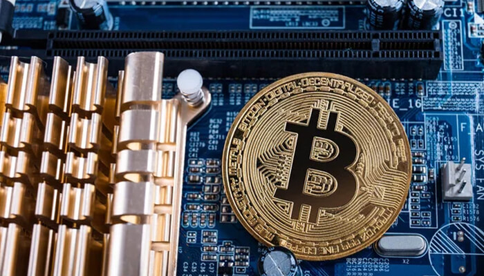 Bitcoin miner management software A bitcoin coin placed on a mining motherboard, symbolizing how bitcoin miner management software interacts with hardware to monitor real-time data such as hash rate, power consumption, and miner temperature.