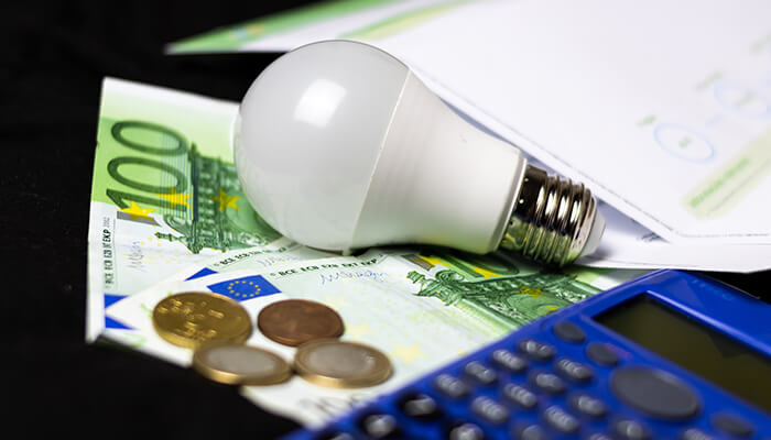 Money spent on electricity Successful businesses finance planning image with calculator, euro notes, coins, and energy-saving investment strategy