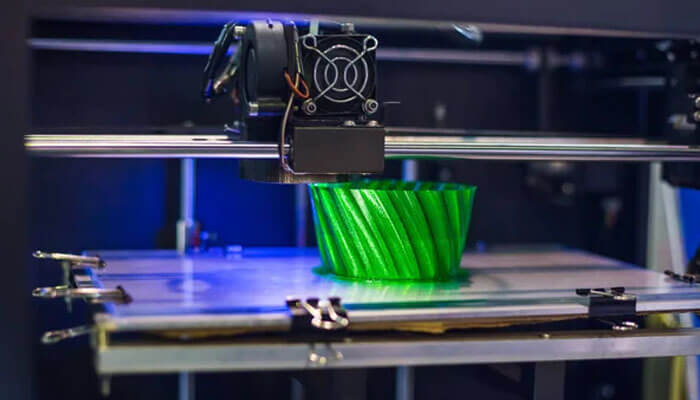 Technologies A 3d printer in action, demonstrating modern technologies with the creation of a green object, illustrating the evolution of manufacturing processes through 3d printing.