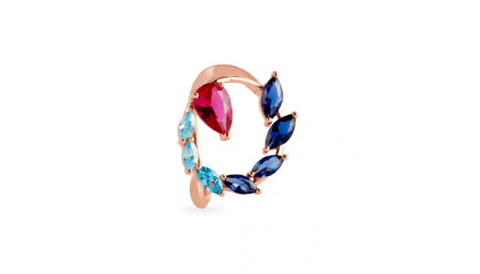 Finger ring - tycoonstory | tycoonstory media Rose gold ear cuff with blue and red gemstones arranged in a stylish spiral design on a white background.