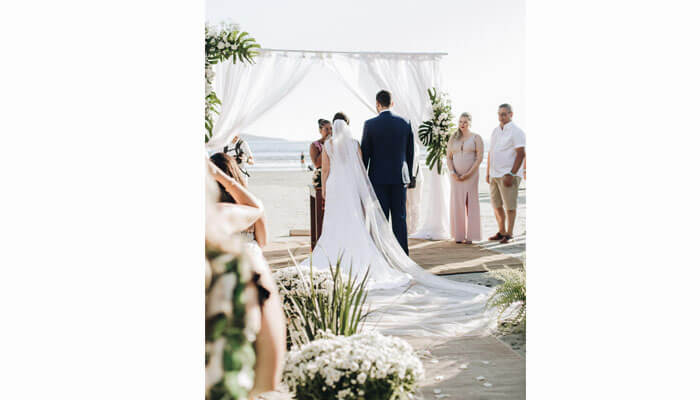Business ideas Couple getting married on a beach, showcasing the growing business ideas around destination weddings and event planning.