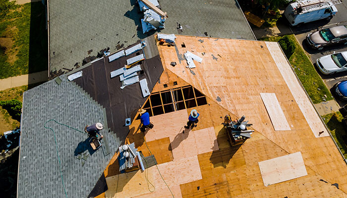 Stable industries An aerial view of a construction crew working on a rooftop, installing new roofing materials, highlighting the active and stable nature of the roofing industry.
