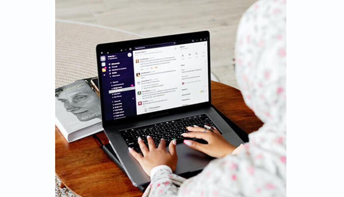 Team2book Remote professional working on a laptop with team2book, managing team communication and bookings from home.