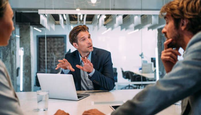 Lawyer Business lawyer discussing terms with clients in a modern office, presenting advice or negotiating on behalf of their business clients
