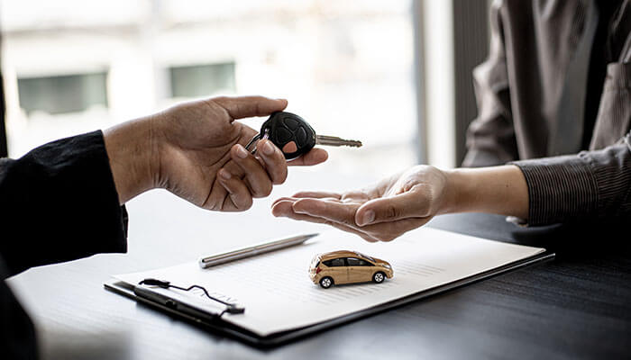 Car rental reimbursement - tycoonstory | tycoonstory media Auto insurance policy agreement showing car keys being handed over, representing vehicle coverage and ownership protection.