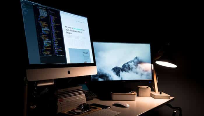 Stay ahead of the curve - tycoonstory | tycoonstory media Modern developer workspace with dual monitors displaying code and design previews, representing a professional website builder service.