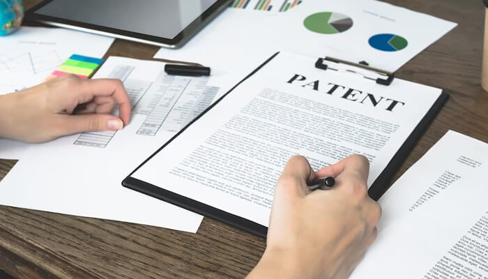Understanding patent grants Legal professional reviewing and signing patent documents as part of the patent grants approval process.