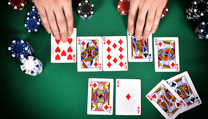 Various rummy game variations - tycoonstory | tycoonstory media Hands playing cards in a rummycircle game, showing various poker chips and a mix of card suits and ranks.