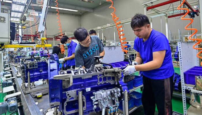 Pmi data - tycoonstory | tycoonstory media Factory workers assembling machinery on a production line in china, showing industrial growth and manufacturing activity. ”