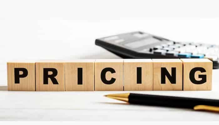 Pricing - tycoonstory | tycoonstory media Pocketsmith pricing concept illustrated by wooden blocks spelling “pricing” with a calculator and pen in the background, representing pocketsmith budgeting plans and cost analysis.