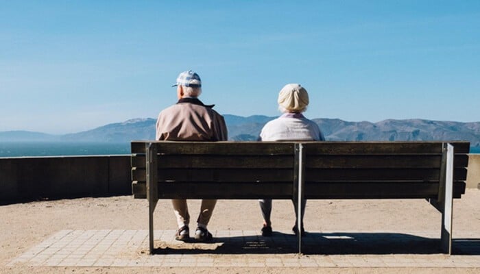 Romtech's Commitment To User Privacy Elderly couple sitting on a bench overlooking a peaceful landscape, symbolizing trust, safety, and romtech's Commitment To User Privacy.