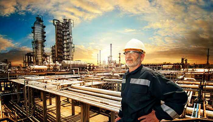 Russia A worker standing in front of an industrial refinery, showcasing the oil and gas industry, a key sector in russia's economy.