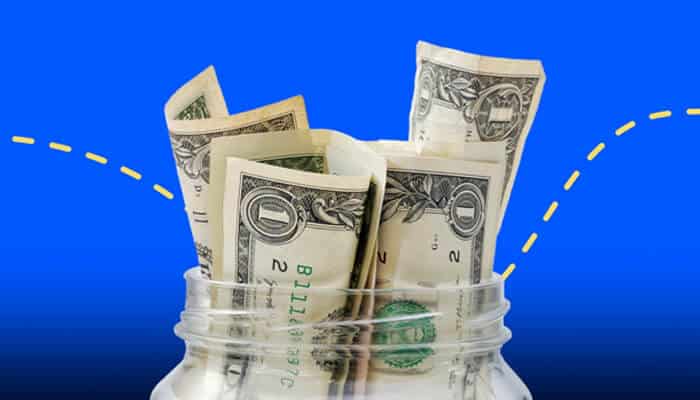 Online Slots "Money bills inserted into a jar, symbolizing savings or investments, with a blue background and a dashed line suggesting growth or accumulation.