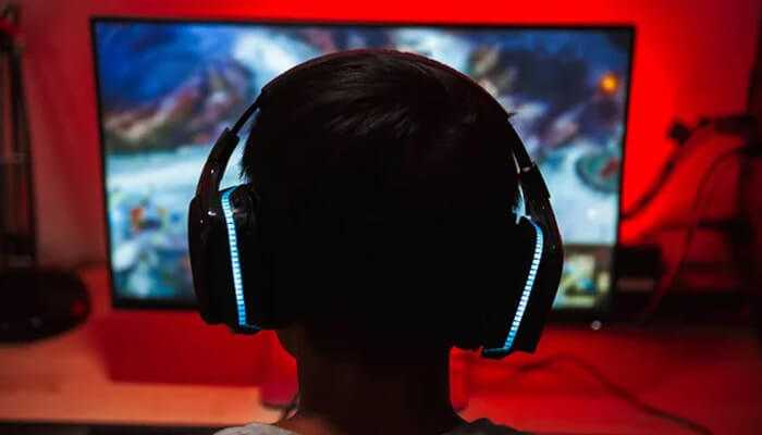 Fnf mods Gamer wearing headphones playing friday night funkin with custom fnf mods on a desktop screen.