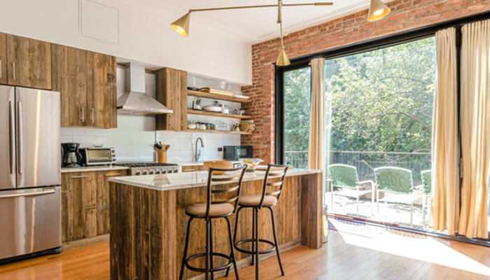 Rustic Rustic kitchen design with wooden cabinetry, modern appliances, and natural light flowing through the large window.