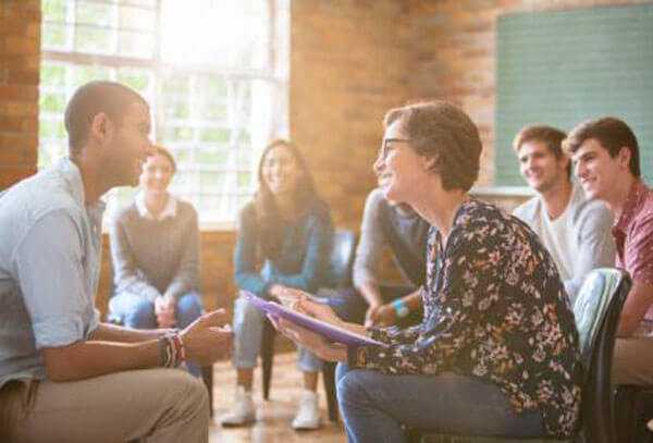 The health benefits of a balanced work-life-tycoonstory | tycoonstory media The image shows a group of people engaged in a meeting, which highlights the health benefits of group discussions.