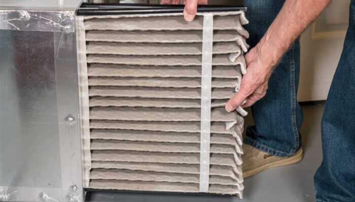 Furnace won't Ignite Close-up of a person holding a dirty furnace filter, highlighting a potential cause for the furnace won't ignite issue due to clogged air filters.