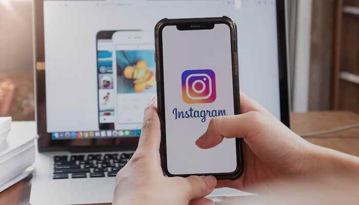 Insfollowpro Person using a smartphone with the instagram logo, symbolizing engagement and follower growth through insfollowpro services.