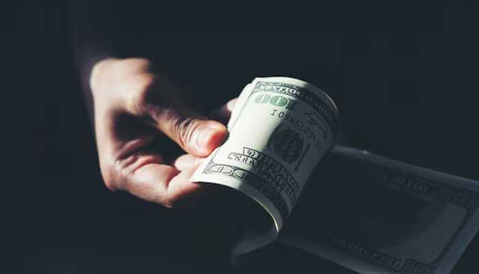 Patrick mahomes net worth Hand holding rolled dollar bills, symbolizing wealth and earnings linked to patrick mahomes’ net worth.