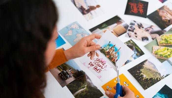 A few steps to know about custom sticker size - tycoonstory | tycoonstory media A person cutting pictures with scissors on a table full of images, showcasing creativity for custom sticker size.