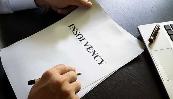 Companys insolvency - tycoonstory | tycoonstory media A person holding a document labeled insolvency highlighting how insolvency can affect your company and the importance of addressing financial challenges