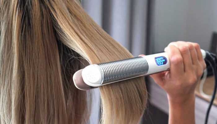 Digital display and smart features - tycoonstory | tycoonstory media A girl using moder hair straightner with a digital display, and highlighting hair straightner technology.