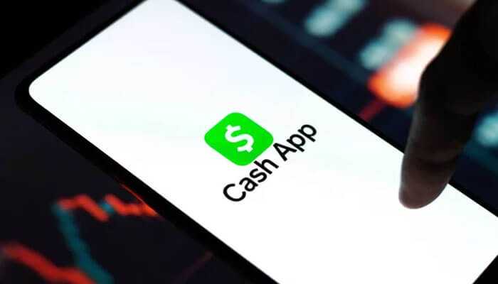 How to use cash app - tycoonstory | tycoonstory media A person using a cash app on mobile with a trading background.