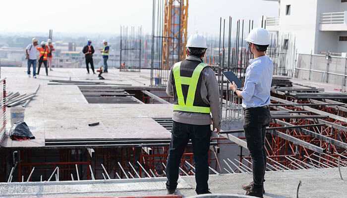 Construction workers using construction asset tracking software to improve security and manage site operations. Construction asset tracking software