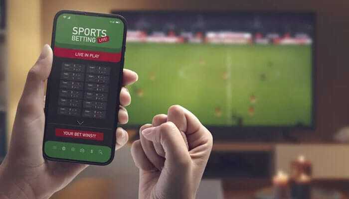 Live betting rates - tycoonstory | tycoonstory media Person using a sports betting app on a smartphone while watching a game on tv, showcasing live betting features on khelo 24 bet.