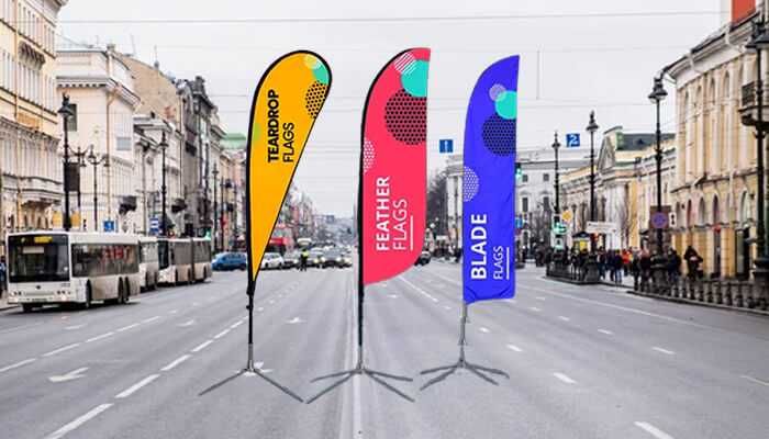 Three custom flags displayed on a busy street, showcasing vibrant designs for effective outdoor advertising, highlighting the use of fabric banners and custom flags. Fabric banners and custom flags
