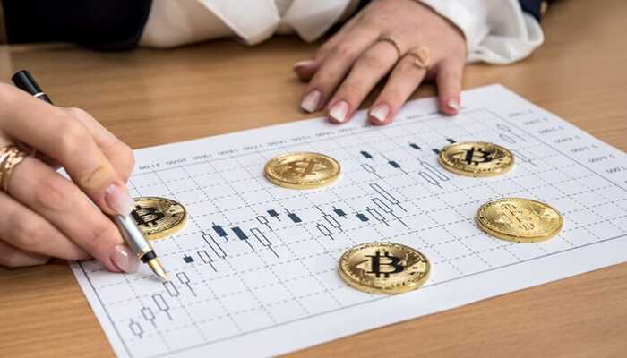 Predictions for bitcoins price - tycoonstory | tycoonstory media A person pointing a pen on a chart with bitcoins, that symbolizing bitcoin price analysis in trading
