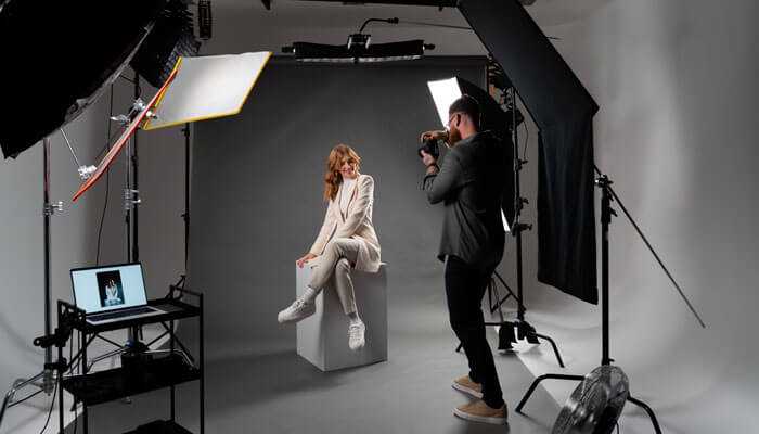 Props and models- tycoonstory | tycoonstory media Photographer shooting in a studio with professional lighting, backdrop, and monitor for clothing photography, featuring a fashion stylist, model, and clothes from an open-source site