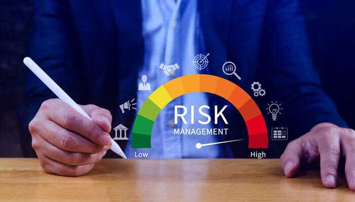 Risk management- tycoonstory | tycoonstory media Businessman reviewing a digital risk management gauge, highlighting the importance of managing risks in crypto payments and blockchain transactions.