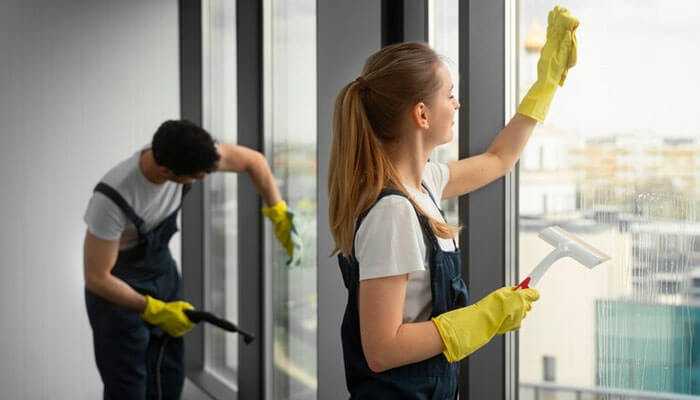 Schedule professional cleaning - tycoonstory | tycoonstory media Professional cleaners performing end-of-lease cleaning as part of a moving out routine, focusing on window cleaning in a rental property